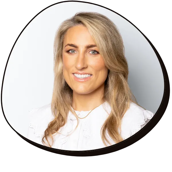 Julie smiles at the camera, she is a white women with medium length blonde hair wearing a white shirt